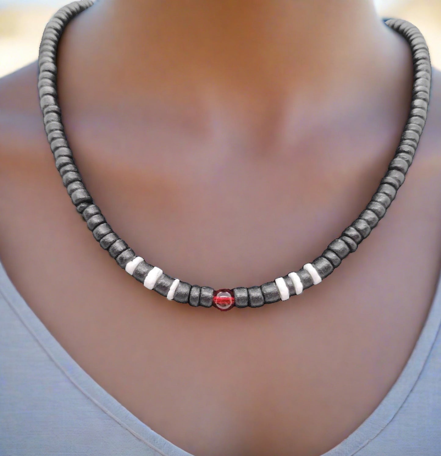 Our black wooden beaded necklace with white wooden beads and a red glass bead as accents.