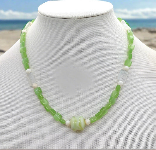 Our apple green necklace up close on a white bust. 